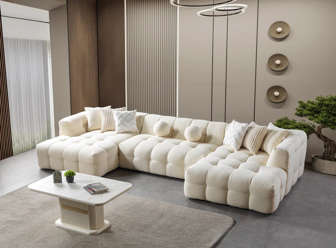 Modern living room with a large white sectional sofa, coffee table, and decorative elements.